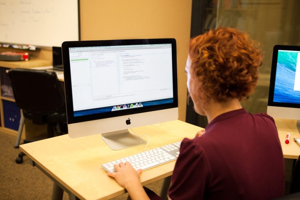 Programmer writing code with unit tests on a monitor